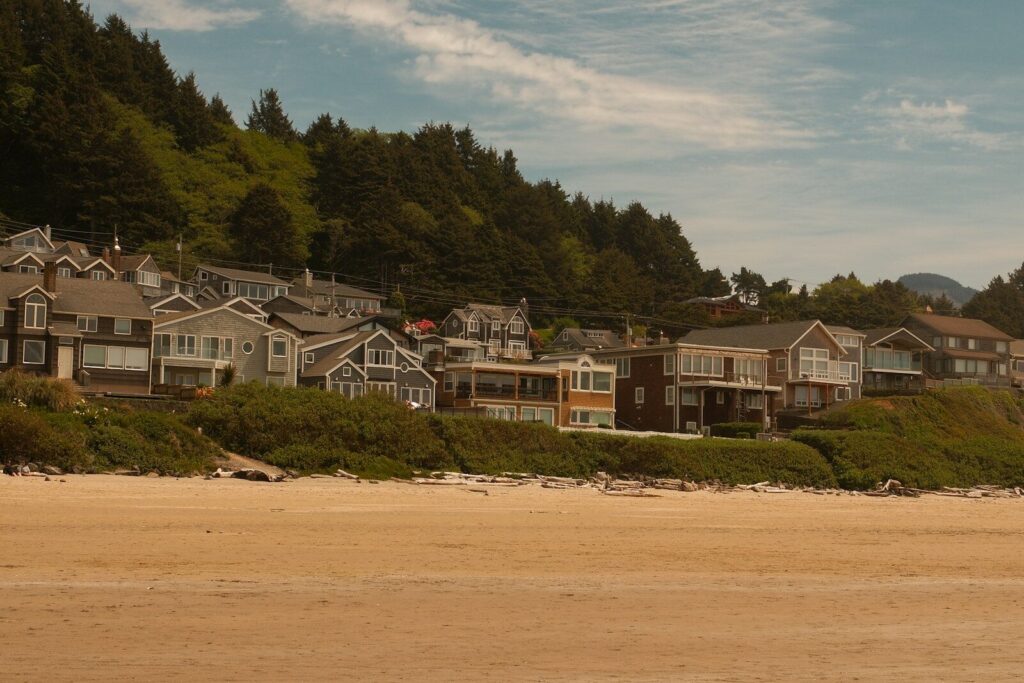 Beachfront houses nestled against a forested hill